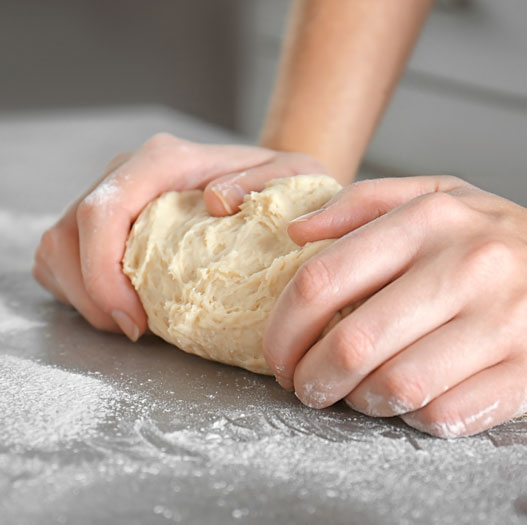 woman-hands-kneading-dough-kitchen-table